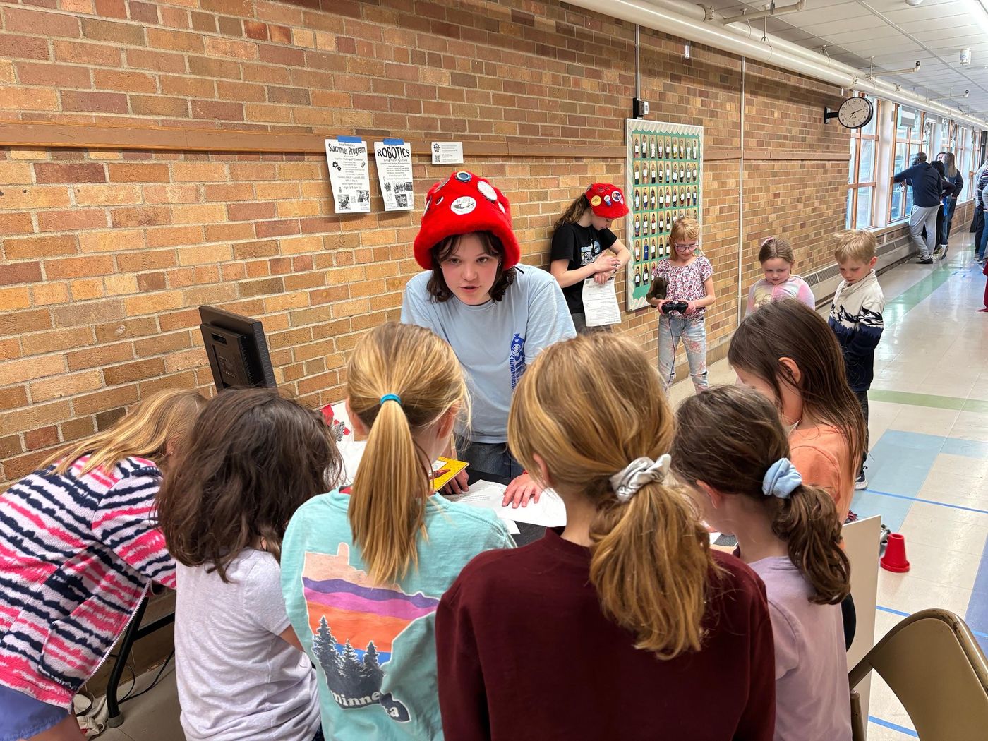 Young students gathered around a team member during an after-school workshop