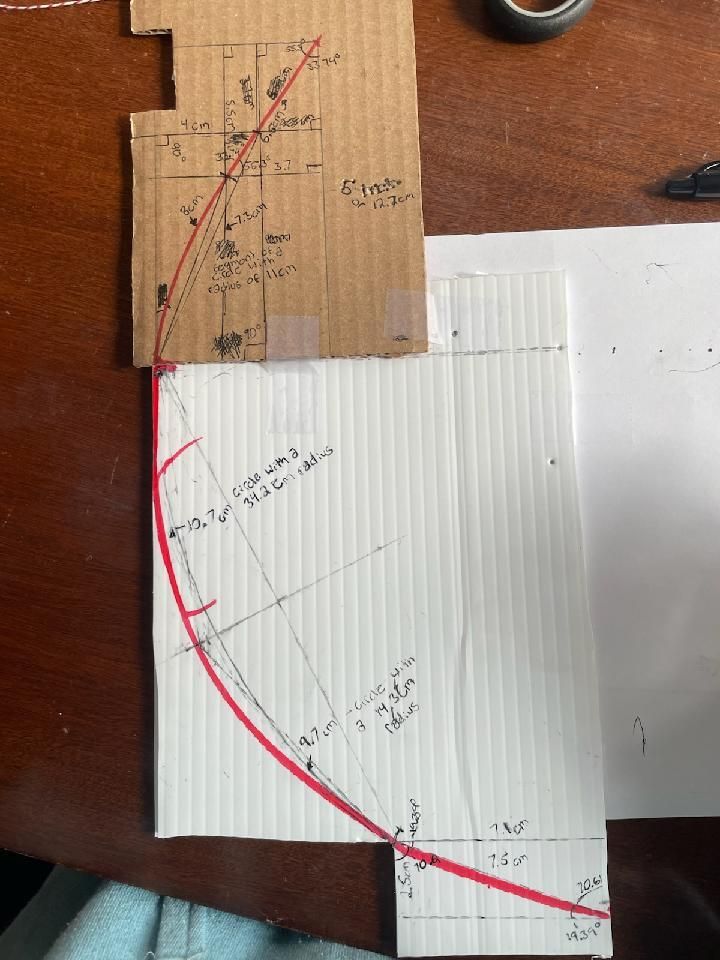 Hand-drawn arc traced from a cardboard ramp prototype
